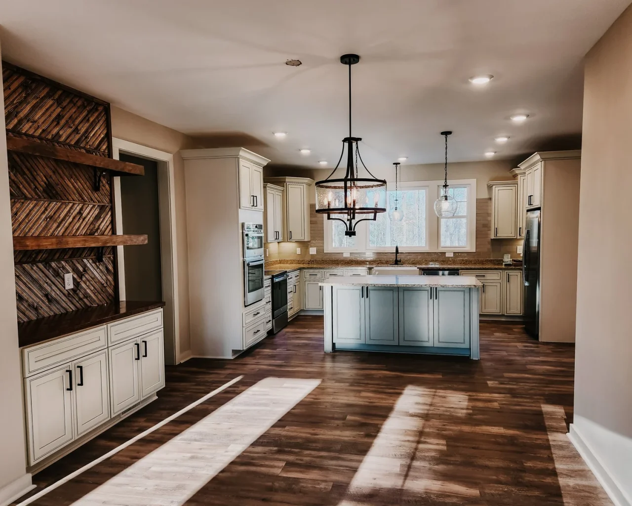 Spacious kitchen in Pauline Country Home with wood floors, elegant lighting, and modern appliances.