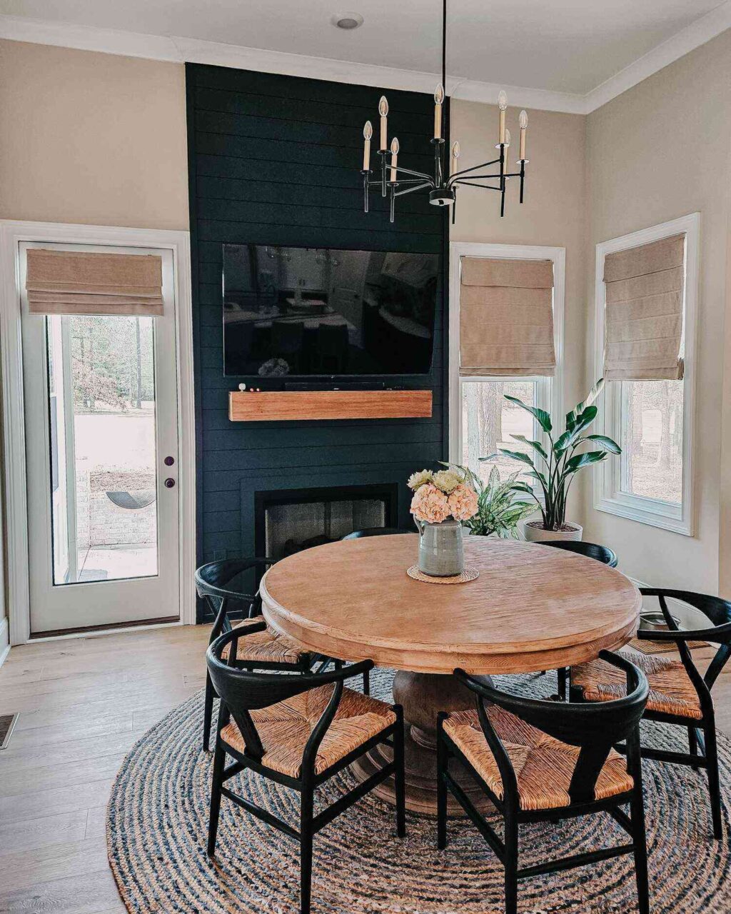 Stylish dining area in a Lake Greenwood home, featuring a round table, chairs, fireplace, and large TV.