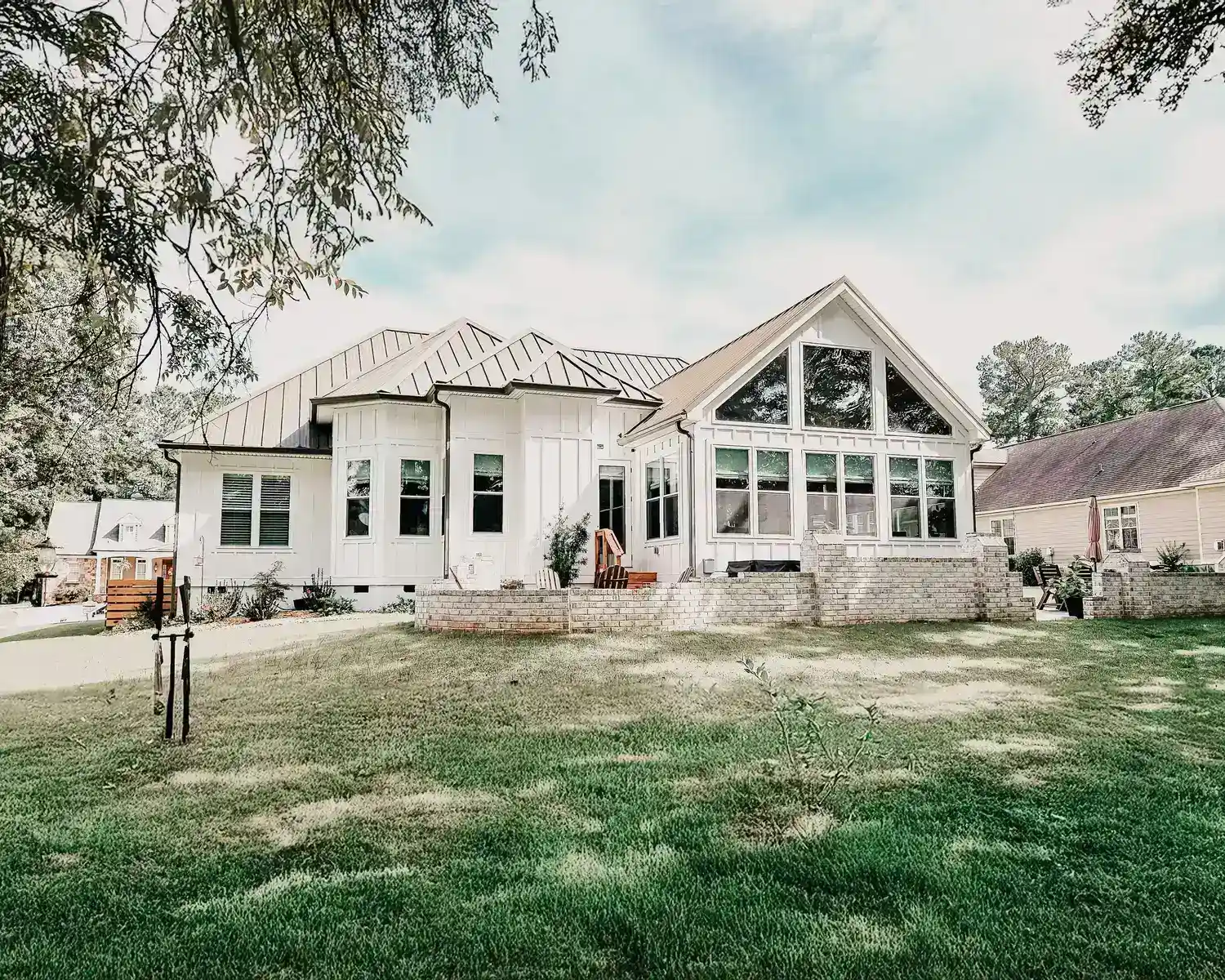 Spacious Lake Greenwood home with large windows, manicured lawn, and surrounding green landscape.