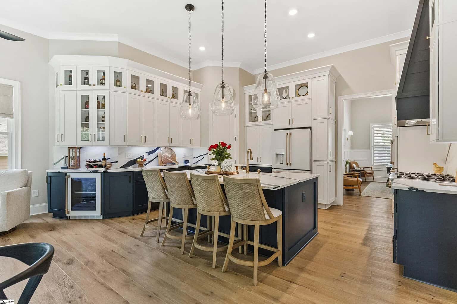 Modern kitchen with a large island, pendant lights, and sleek cabinets exemplifying exceptional craftsmanship in home building.