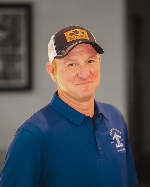 Man in blue polo and cap, representing Josh Timms Builders, embodying custom homebuilding standards.