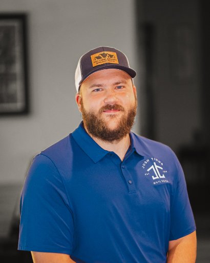 Man in a blue Josh Timms Builders shirt and cap, embodying the higher standard in custom homebuilding.