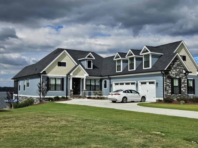 Custom home on your land in Upstate SC, showcasing finished construction with driveway and car.